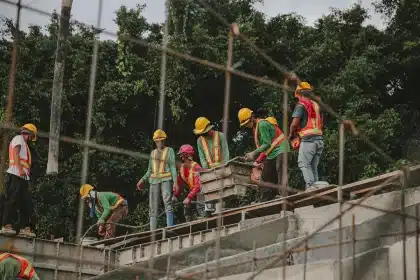 Trabajadores de la construcción en una obra con cascos y equipos de seguridad.