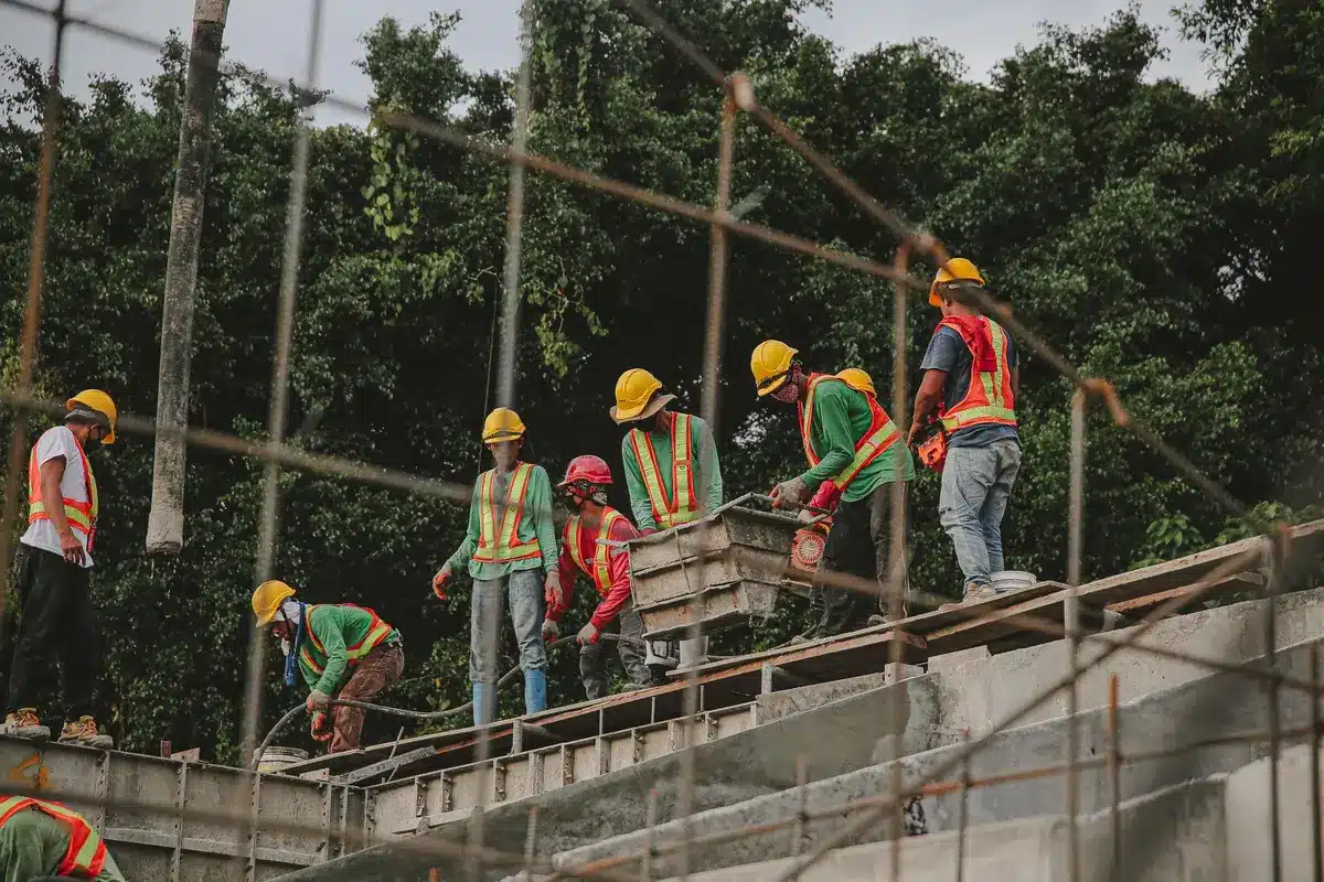 Trabajadores de la construcción en una obra con cascos y equipos de seguridad.