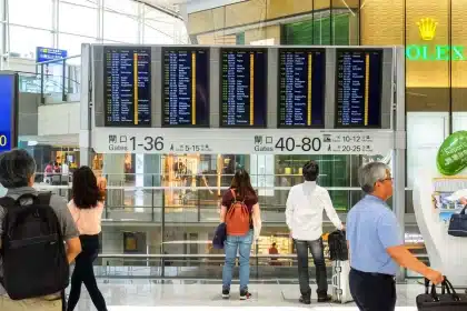 Jóvenes estudiantes con mochilas en una terminal de aeropuerto, preparándose para un viaje internacional.
