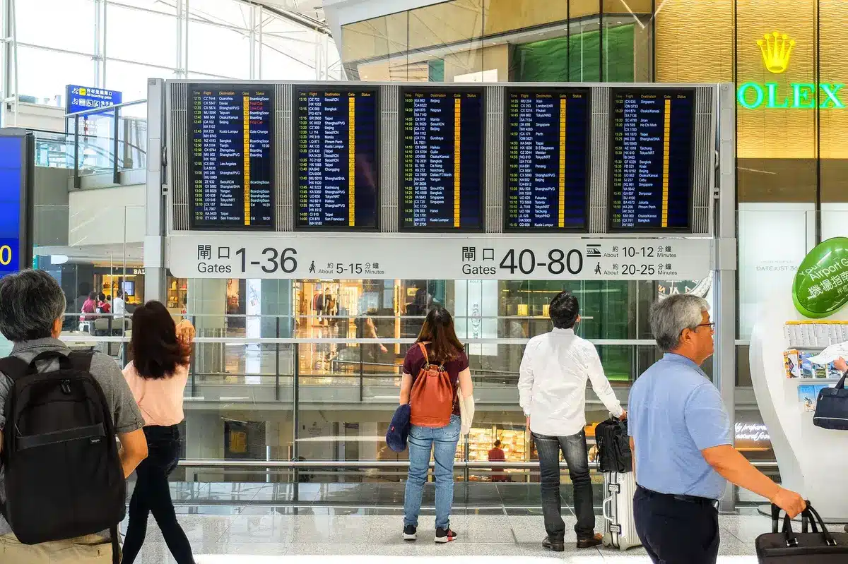 Jóvenes estudiantes con mochilas en una terminal de aeropuerto, preparándose para un viaje internacional.