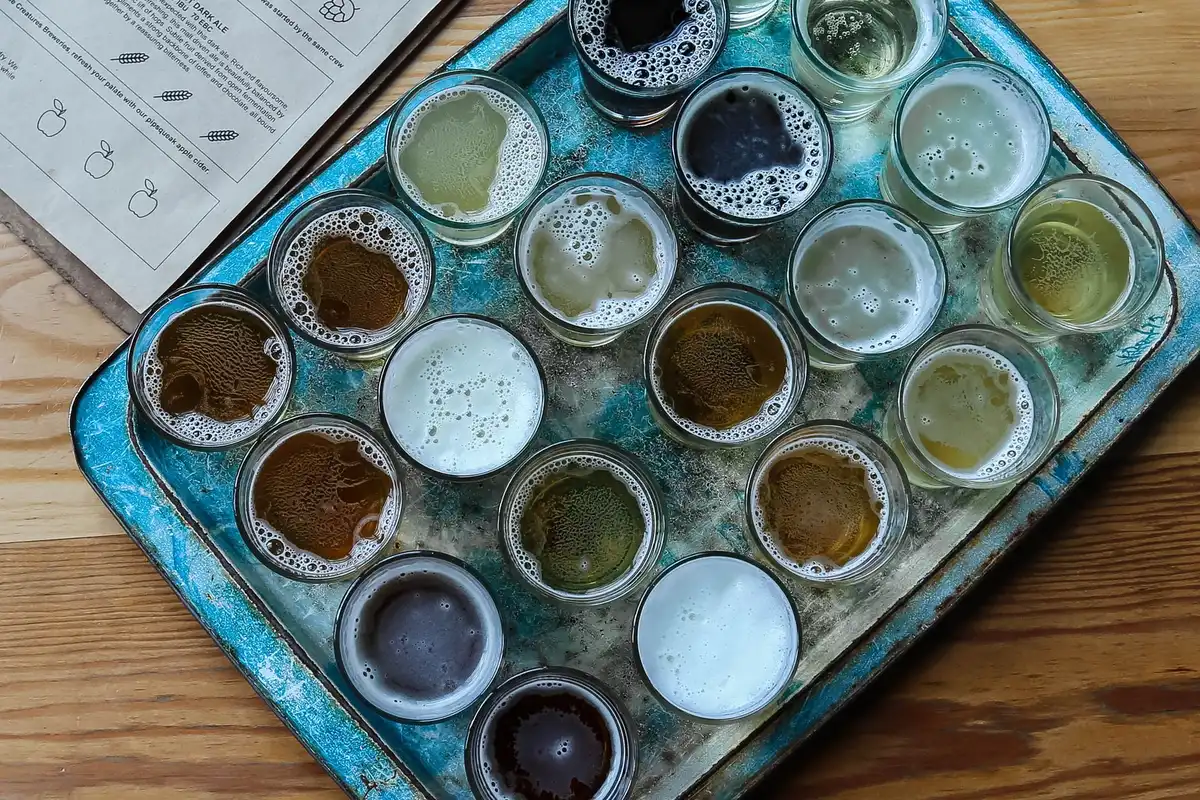 Variedad de botellas y vasos de cerveza de diferentes estilos y marcas internacionales.