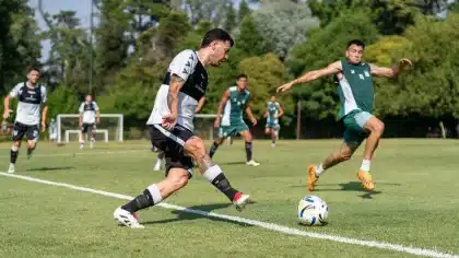 Joven defensa en equipación de entrenamiento caminando hacia las instalaciones de una academia de fútbol