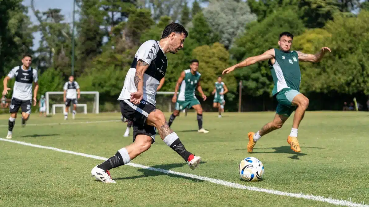 Joven defensa en equipación de entrenamiento caminando hacia las instalaciones de una academia de fútbol