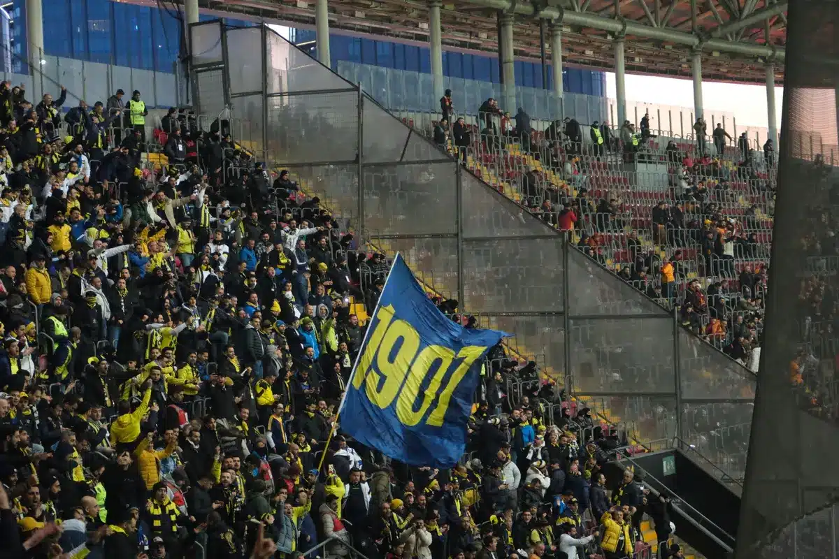 Aficionados en la grada de un estadio durante un partido de fútbol