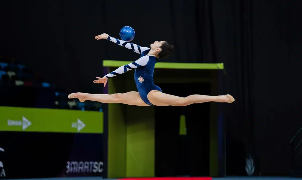 Momento de ejecución en rutina de gimnasia rítmica con pelotas.