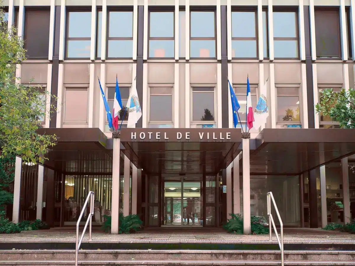 Fachada de ayuntamiento con documentos presupuestarios y elementos de infraestructura sostenible