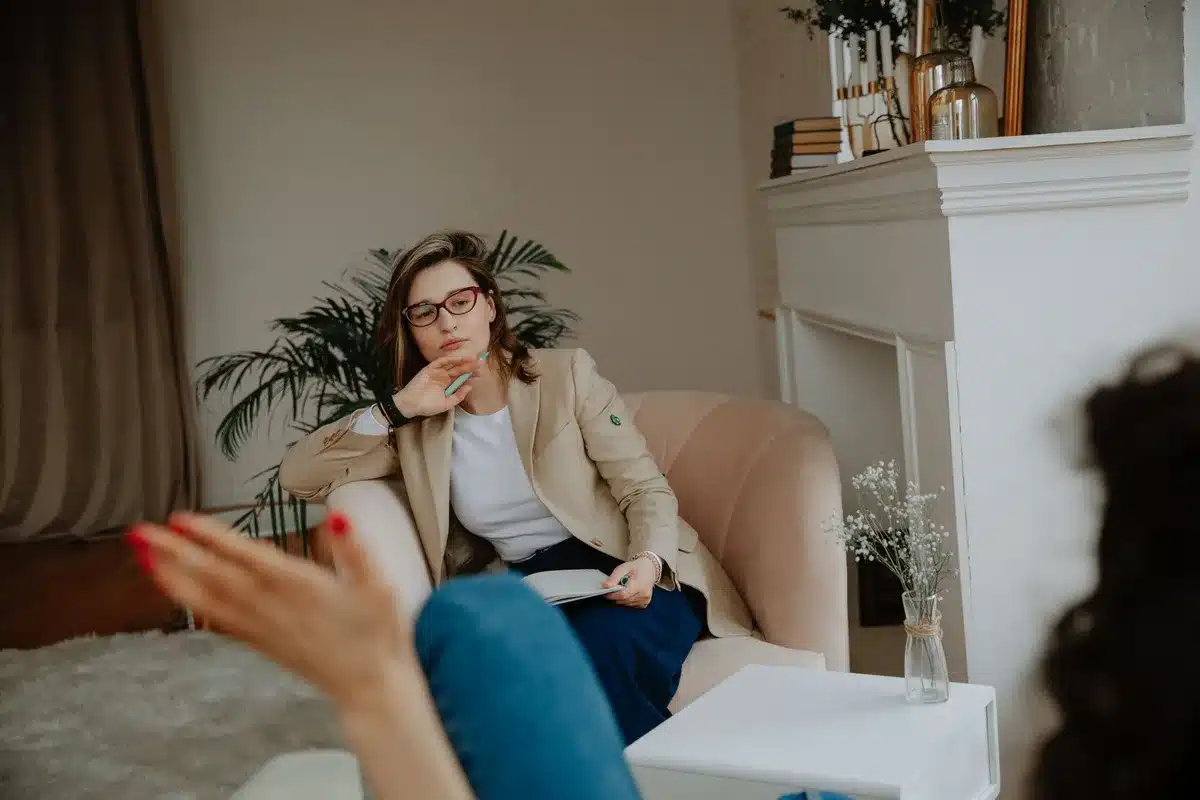 Mujer reflexionando en un espacio tranquilo, expresi&oacute;n de introspecci&oacute;n y conciencia emocional.