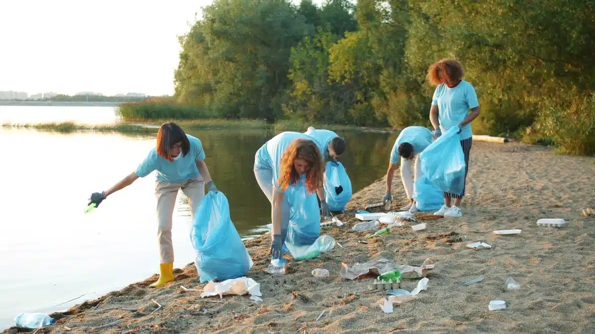 Grupo de personas participando en una jornada de sensibilización ambiental en la costa.