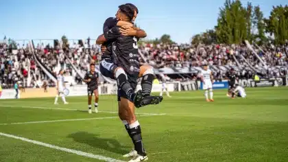 Jóvenes futbolistas celebrando un gol durante un partido amistoso