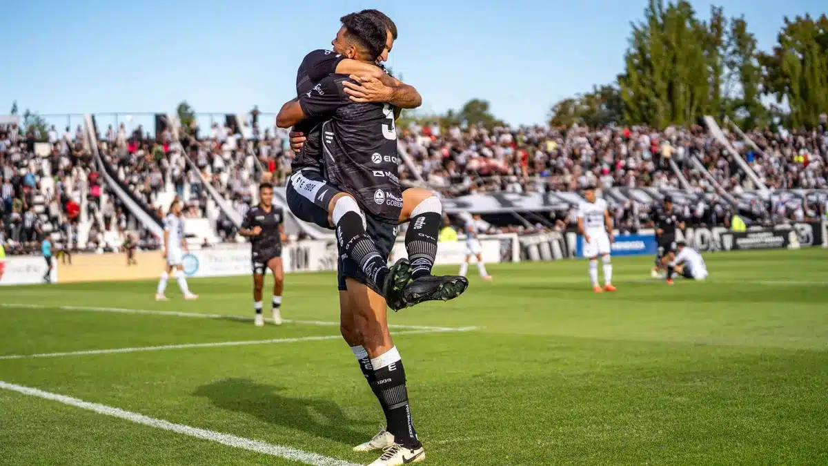 Jóvenes futbolistas celebrando un gol durante un partido amistoso