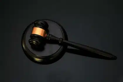 Documentos legales y gavel en escritorio administrativo, simbolizando aplicación de la ley y justicia