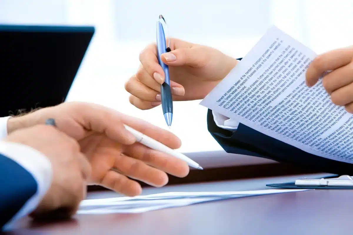 Documentos de nómina y cálculos salariales sobre un escritorio.