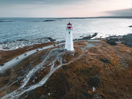 Costa rocosa con mar agitado y hierbas sopladas por el viento bajo cielo tormentoso