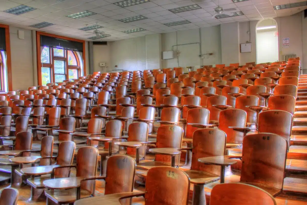 Sala de aula vacía y atril que evoca un discurso universitario