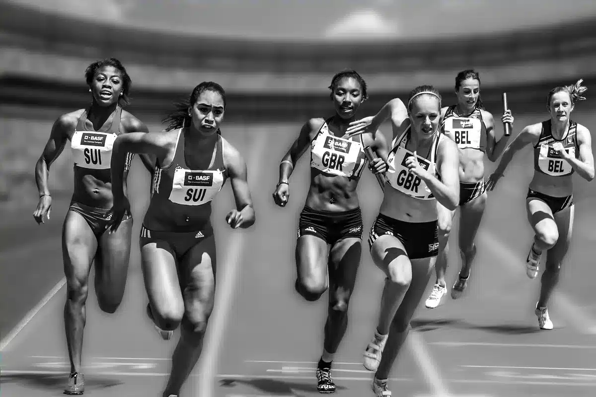Grupo de atletas españoles cruzando la meta en una maratón, celebrando el logro colectivo.