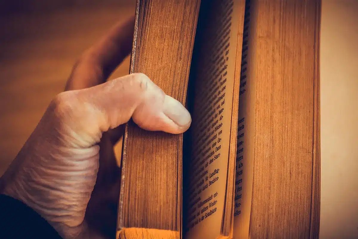 Manos sosteniendo un libro de poesía abierto, detalle íntimo