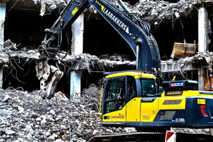 Maquinaria y pantallas de protección en una demolición urbana junto a un túnel
