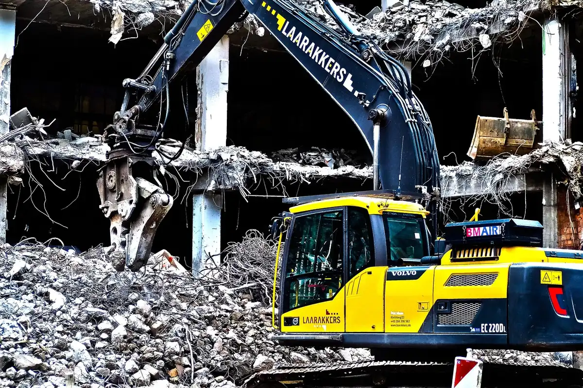 Maquinaria y pantallas de protección en una demolición urbana junto a un túnel