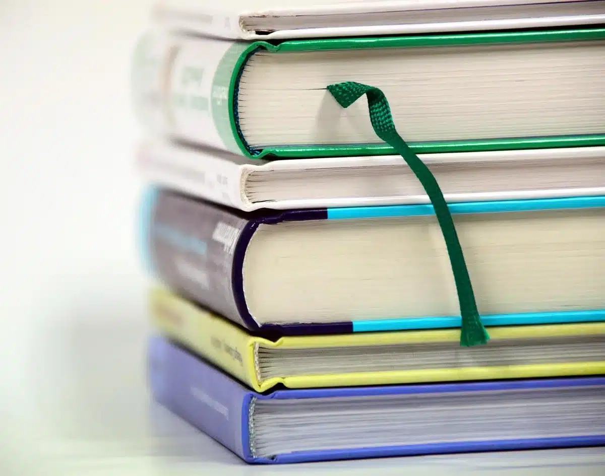 Libros apilados que combinan memoria y ficción sobre una mesa
