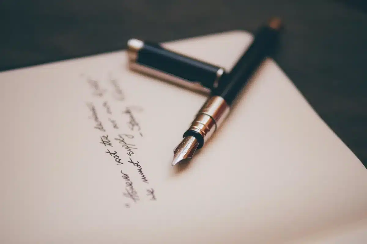 Cartas escritas a mano apiladas junto a sobres sobre un escritorio