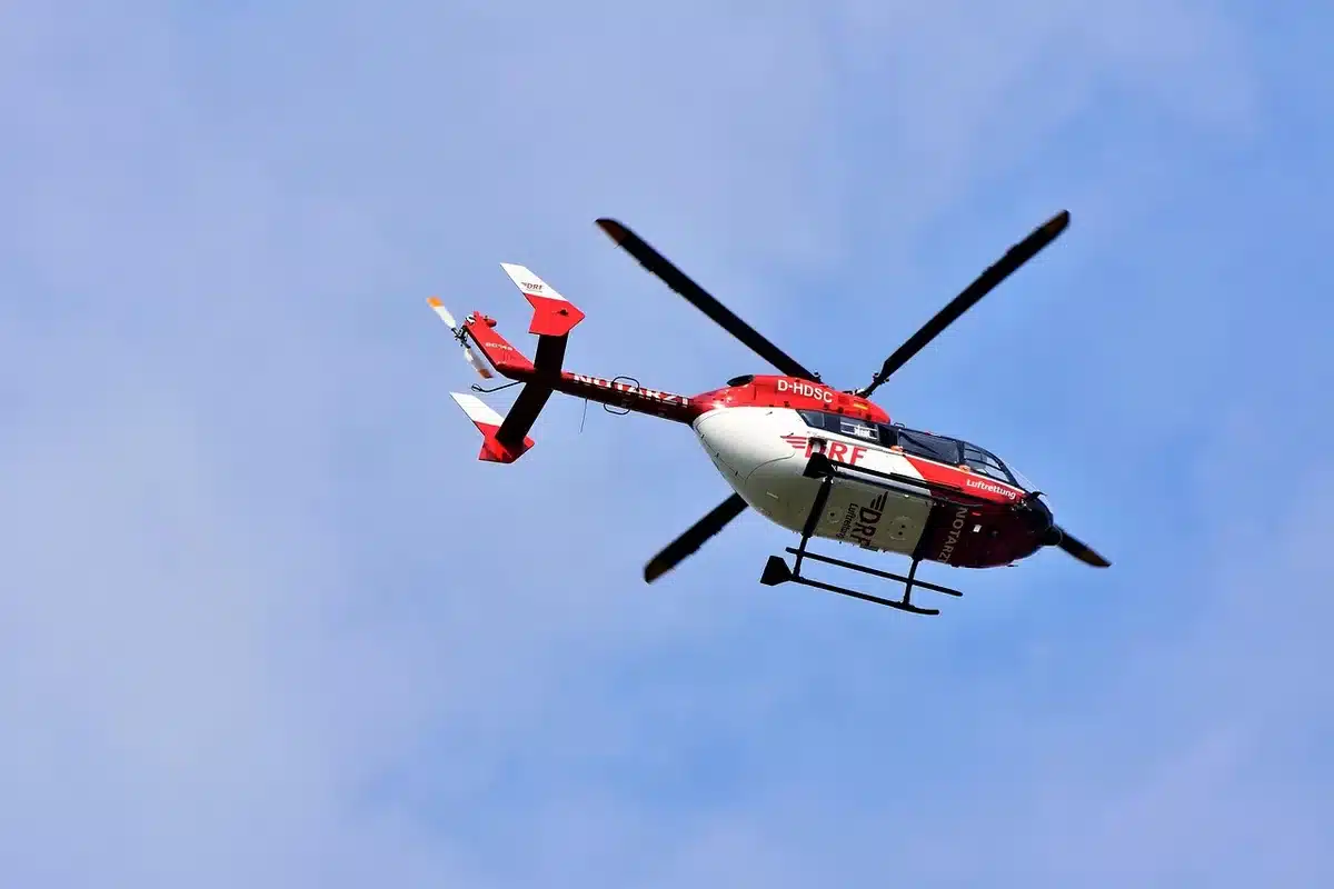 Helicóptero de rescate evacuando personas desde zona de desastre en montaña