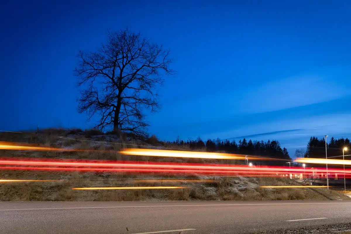 Tramo de carretera nocturno con conos y luces de emergencia