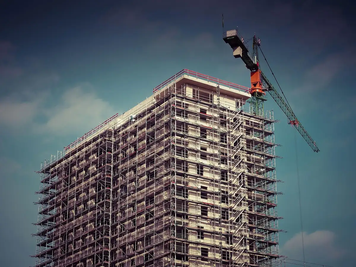 Grúas y obra en curso que ilustran la construcción de viviendas