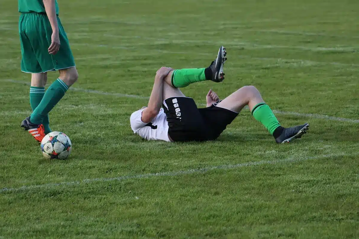 Sesión de fisioterapia en tobillo de un futbolista en el campo