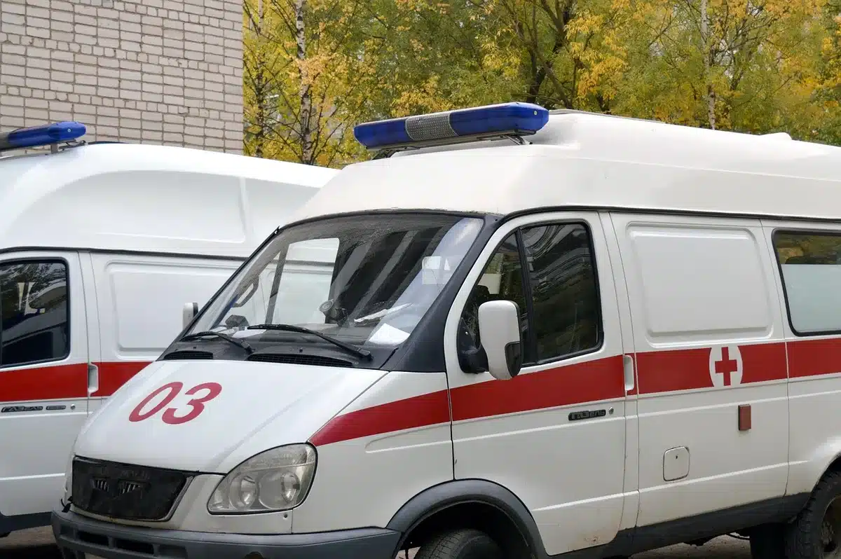 Ambulancia y personal sanitario en la entrada de un hospital atendiendo heridos